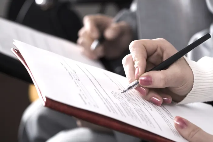 Hand filling out a patient form